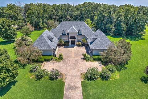 Located in one of Bentonville's most sought after subdivisions, this custom-built builder owned masterpiece exudes luxury throughout and is nestled on a gorgeous 3.64 acre corner lot featuring a detached 1,200 sq ft guest house and a beautiful in gro...