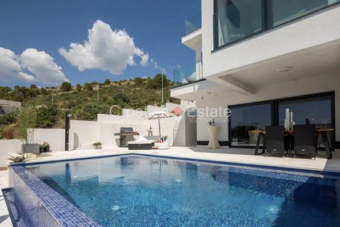 We are selling a modern villa with two residential units, located in Rogoznica, only 100m from the sea, on a steep terrain, right next to two asphalt access roads, one of which is above and the other one next to the villa. One of the main highlights ...