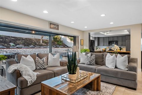 Stunningly renovated East Lake Village Yorba Linda two-story home with a captivating, expansive sliding WOW door, offering a seamless indoor-outdoor living experience. 20545 Via Campanas features travertine flooring throughout the main level, this ho...