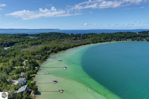 Located on the south shore of North Lake Leelanau at the end of a private road just 2.1 miles from Leland. Perfect all sports lake lifestyle with 121 feet of hard sand lake bottom. Open floor plan with a classic natural field stone fireplace, two mas...