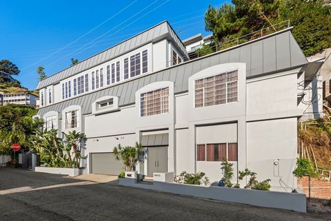 Sited just above the famed Sunset Strip, this midcentury style home has 3 bedrooms and 4 bathrooms. The first floor consists of a den/ library completed by floor to ceiling bookshelves. Ascend a flight of stairs to the main level which consists of li...