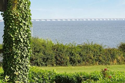 Holiday home located high on a sloping plot by Tårup Strand with a view of the Great Belt and the Great Belt Bridge. The cottage contains a living room with open kitchen and dining area. The sleeping accommodation is divided into two bedrooms, one wi...