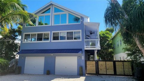 JUST REDUCED! Furnished & remodeled larger than most of the homes in the FL Keys. 6 BEDS/4BATH DONT MISS IT Located above flood in an XFLOOD zone with 3 floors of living space and 3 full garages for all of your toys! This home is mother-in-law friend...