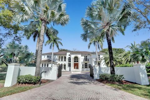 Two Story Mediterranean Estate in North Pinecrest situated on a deep tropical acre. Walled entry offering security and privacy. Distinguished entry with soaring ceiling and beautiful grand staircase. Elegant formal dining room, and formal living room...