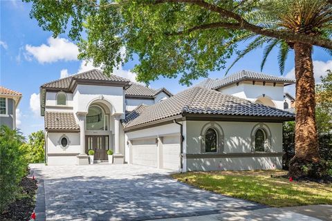 Exquisite three-story REMODELED lakefront residence situated within the prestigious 24-hour guard-gated community of Vizcaya. Positioned along the serene shores of Big Sand Lake, this 