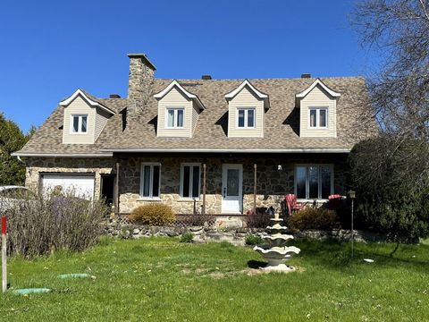 Enjoy the tranquility of the countryside with this charming Canadian house located on a lot of almost 54,000 sq. ft. Let yourself be charmed by the stone facade, the large front gallery and the mature trees. Inside you will find a renovated kitchen w...