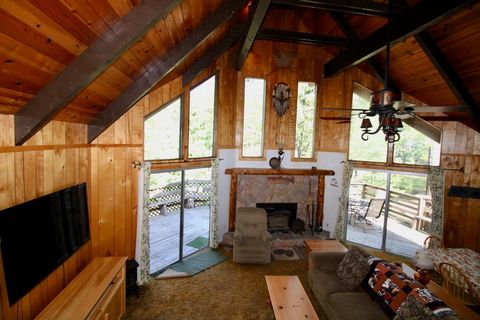 Cute, Cute, Cute. This vintage cabin has a large open area with the living area that features soaring vaulted, open beam, knotty pine ceilings to provide a wide-open feeling, picturesque windows to let in the sunshine and to see the trees, stone fire...