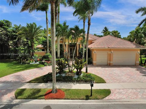 Custom estate in prestigious neighborhood of Poinciana at Weston Hills CC. Situated on 16,345 sqft lot with circular driveway surrounded by royal palm trees and lush landscaping for ultimate privacy. Step inside to large windows that captivate water ...