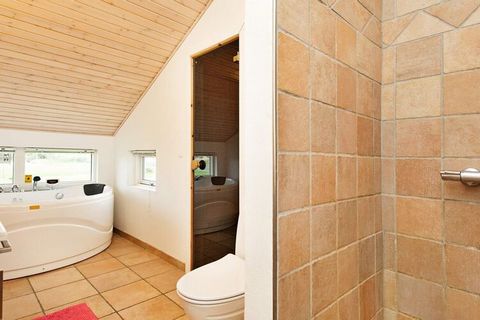 This holiday cottage is located approx. 500 metres from a sandy beach, with a whirlpool and sauna, perfect for relaxation after long days. The house sits on a fenced-in plot and has a large terrace of 40 m² and a covered terrace of 8 m². This is perf...